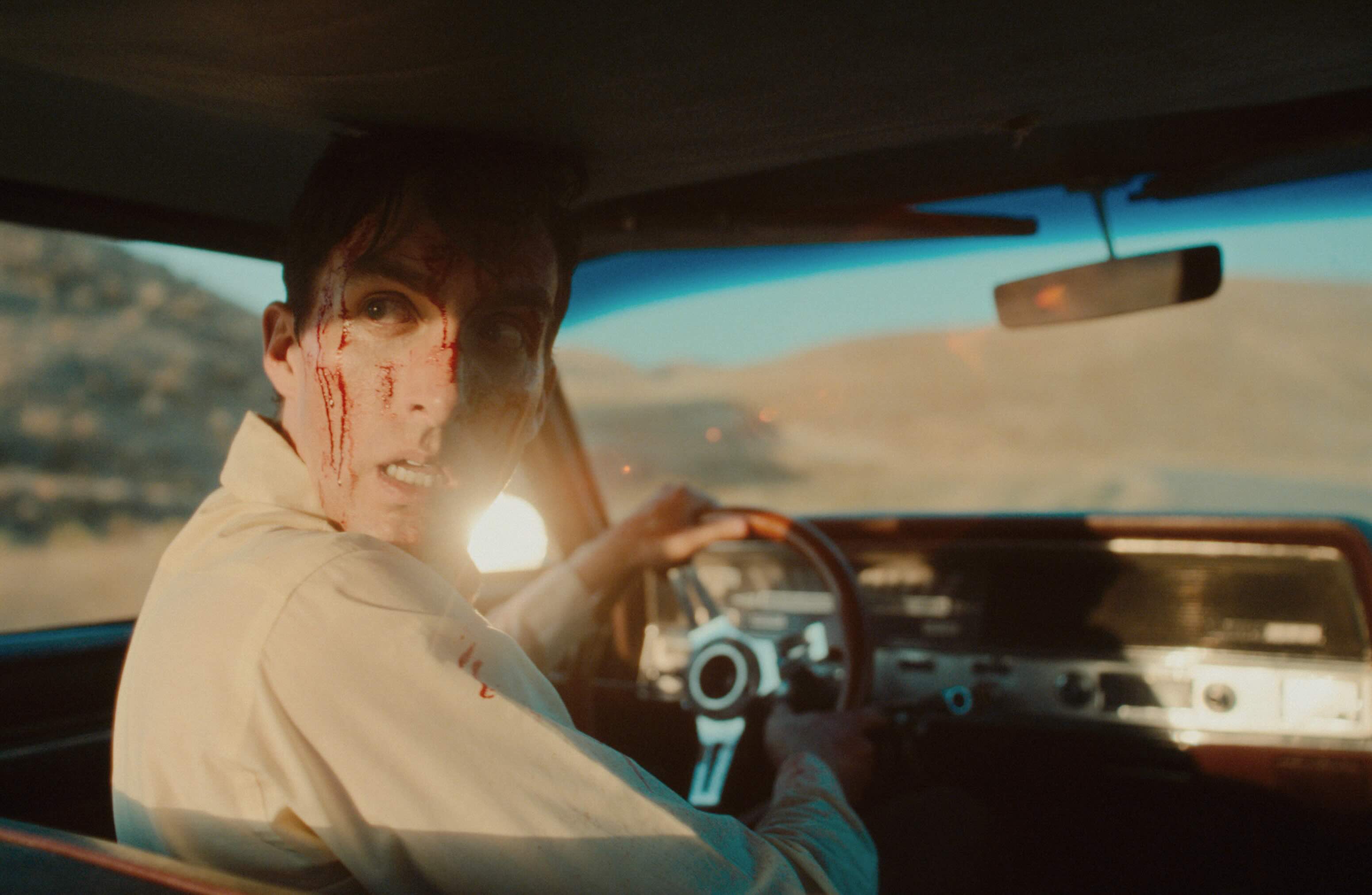 Anxious man driving, covered in blood