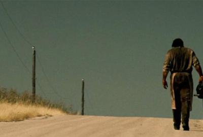 Leatherface walking up dirt road