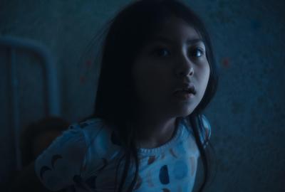 Little girl in bed staring at something terrifying off screen