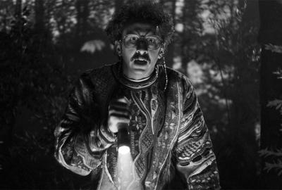 A man holds a flashlight in the woods