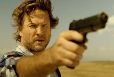 Asher points a gun