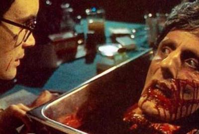 Re-Animator Dr. Herbert West looks at the living head in a pan