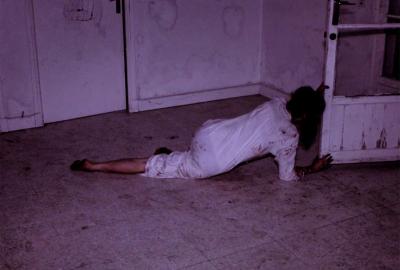 Therapy film still woman crawls to the door.