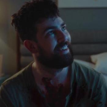 director, Danny Whalen in a still from a movie, looking up and smiling sadly